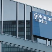Business professionals overlooking a city financial district as global M&A activity rebounds amid heightened regulatory scrutiny and transaction complexity.
