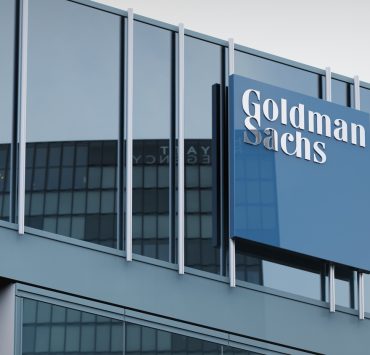 Business professionals overlooking a city financial district as global M&A activity rebounds amid heightened regulatory scrutiny and transaction complexity.