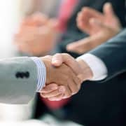 Business professionals reviewing financial data representing record global mergers and acquisitions activity during the first half of 2026.