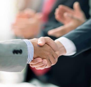 Business professionals reviewing financial data representing record global mergers and acquisitions activity during the first half of 2026.