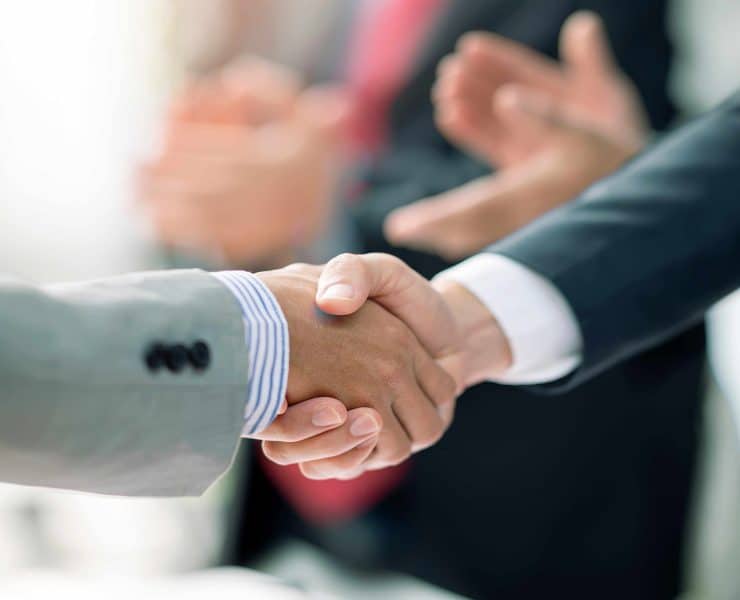 Business professionals reviewing financial data representing record global mergers and acquisitions activity during the first half of 2026.