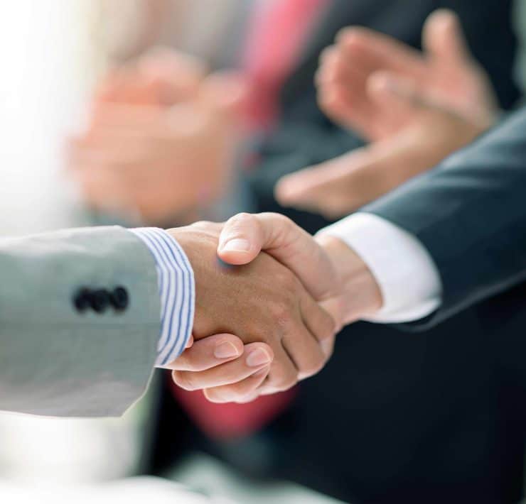 Business professionals reviewing financial data representing record global mergers and acquisitions activity during the first half of 2026.