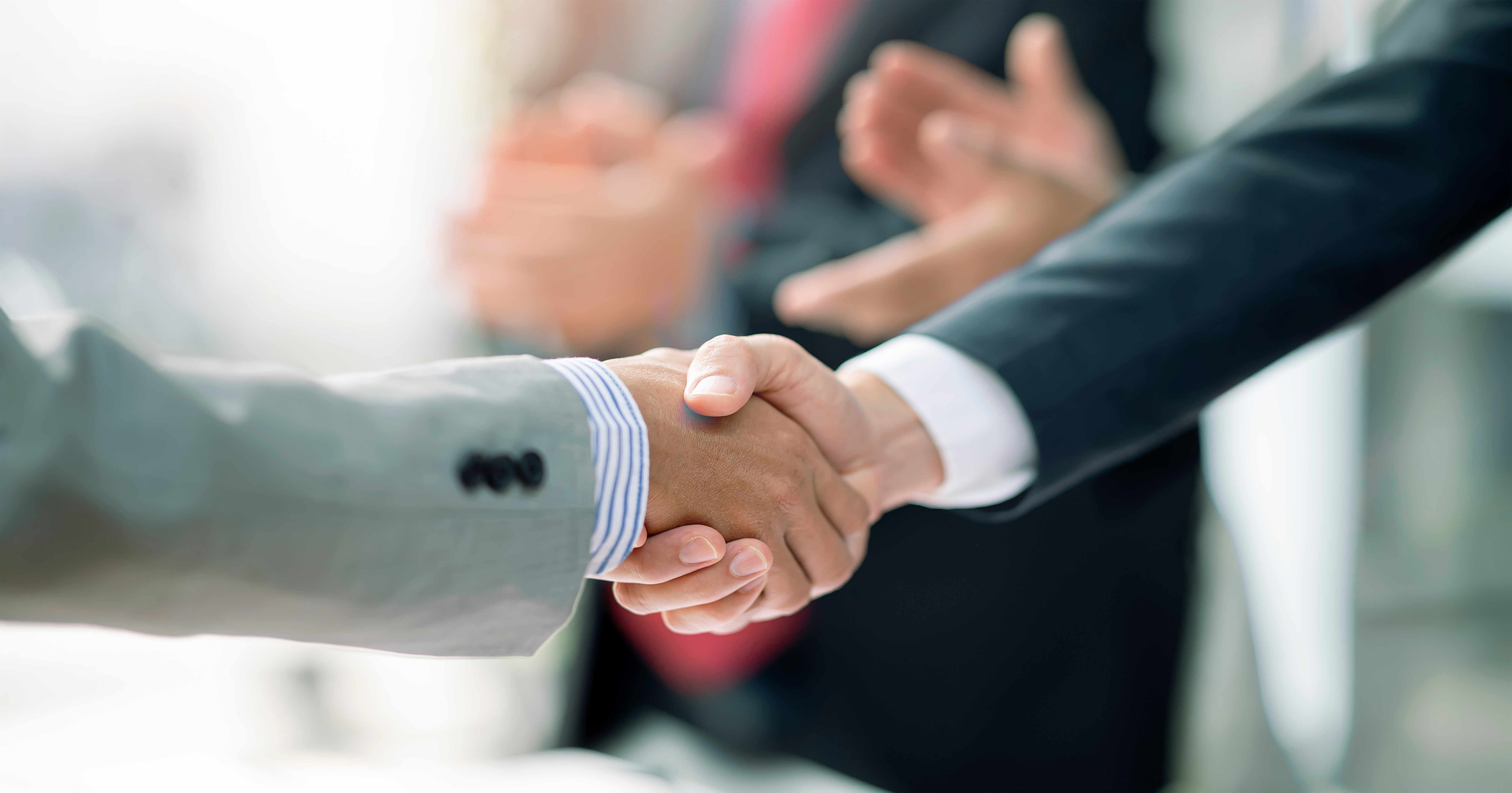 Business professionals reviewing financial data representing record global mergers and acquisitions activity during the first half of 2026.