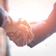 Legal professionals shaking hands illustrating the importance of trust, governance and human oversight in legal AI adoption.