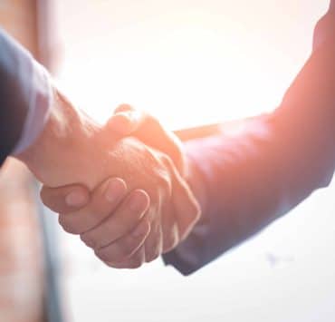 Legal professionals shaking hands illustrating the importance of trust, governance and human oversight in legal AI adoption.
