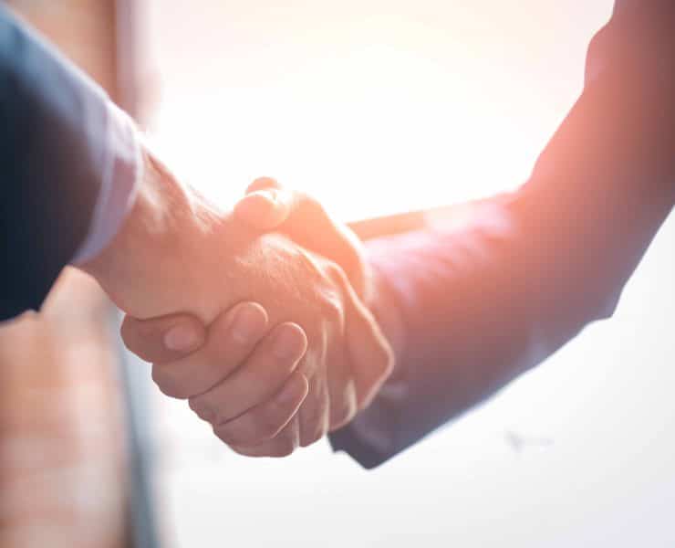 Legal professionals shaking hands illustrating the importance of trust, governance and human oversight in legal AI adoption.