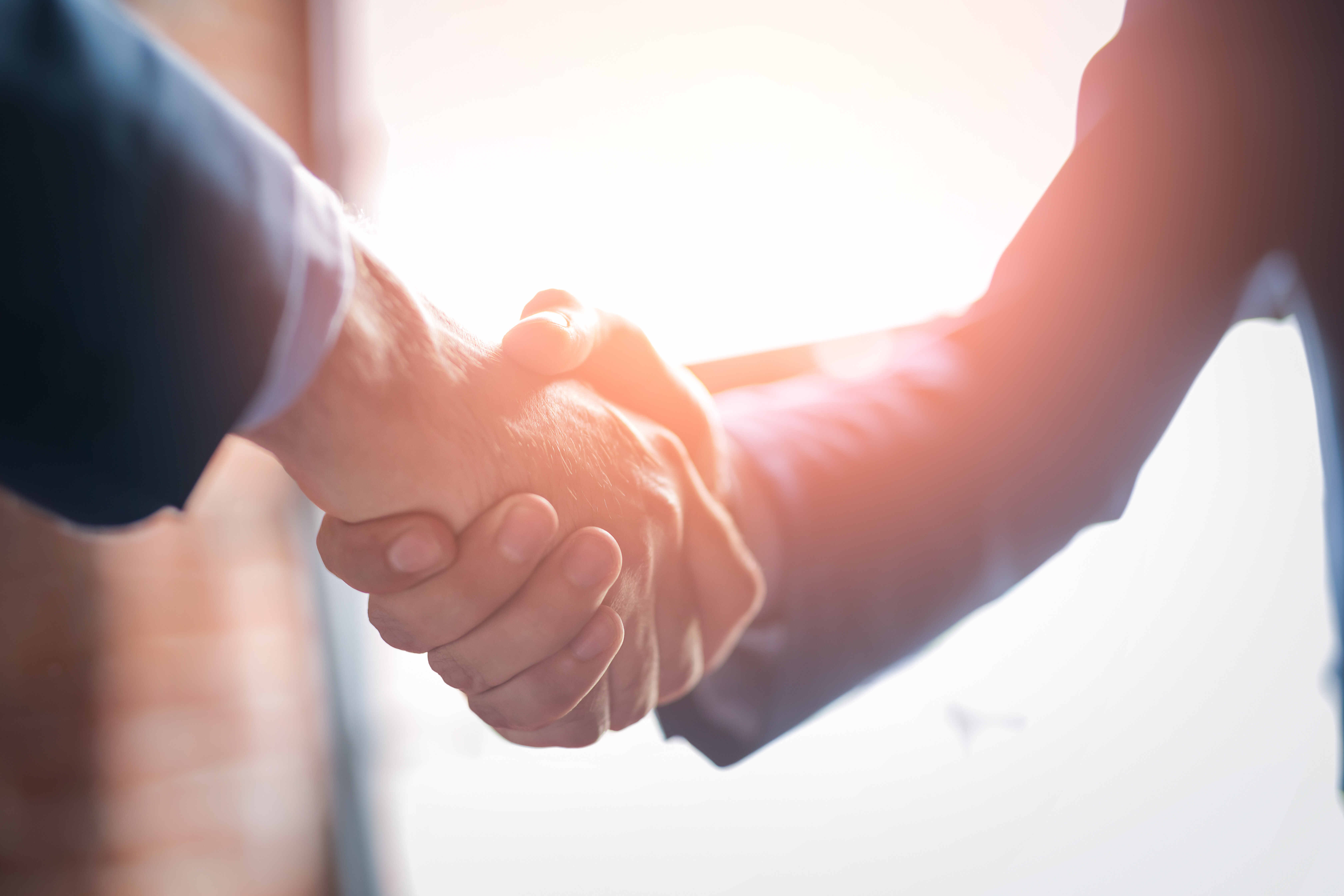 Legal professionals shaking hands illustrating the importance of trust, governance and human oversight in legal AI adoption.